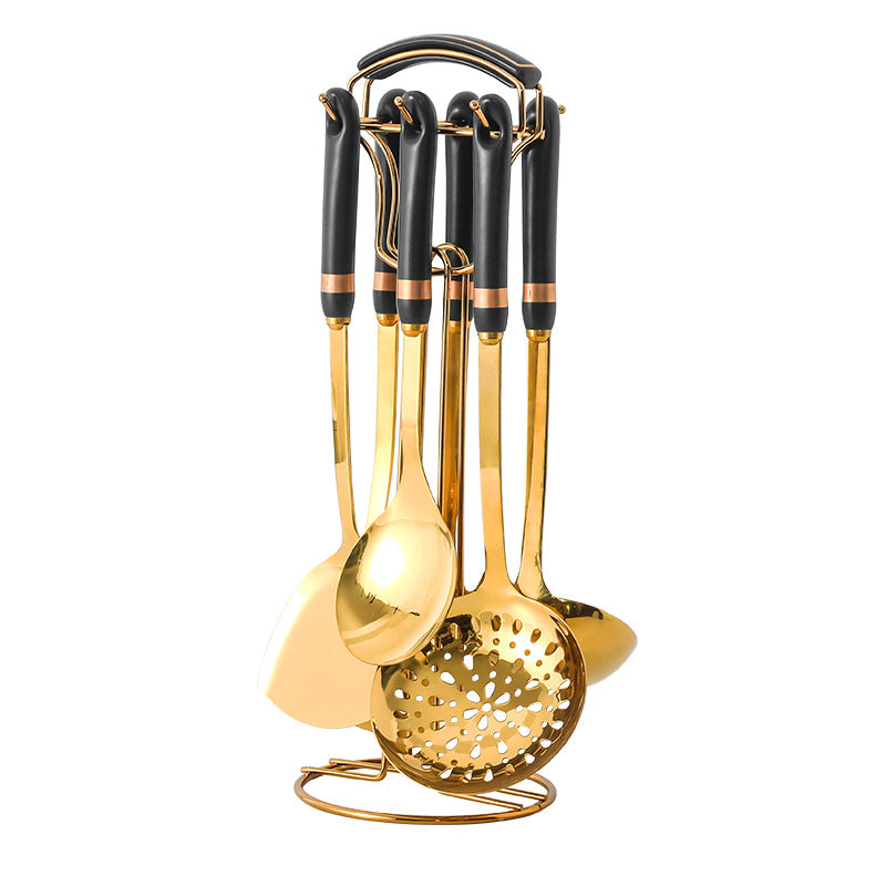 Set of gold and black kitchen utensils on a white background