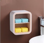 Wall-mounted shelf with blue and yellow sponges against a brown wall.