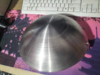 Metallic bowl on a pink and purple mouse pad with a keyboard in the background