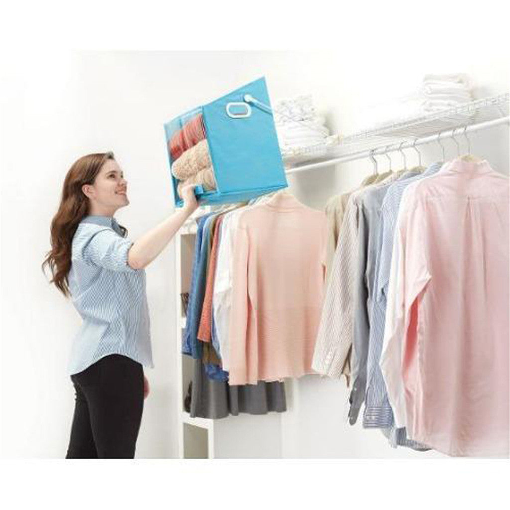 Woman organizing clothes in a closet using a blue folding board.