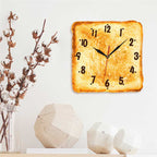 Square wall clock designed to look like a piece of toast with black numbers and hands on a white background.
