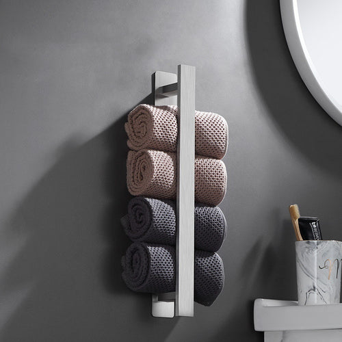 Towel rack with rolled towels against a gray wall in a bathroom setting