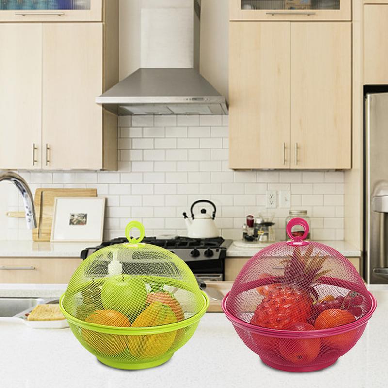 Two mesh fruit covers, one green and one pink, with fruits inside on a kitchen counter.