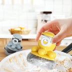 Yellow kitchen scrubber held by a hand over a pot with a blurred kitchen background