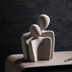 Abstract sculpture of three figures on a dark background