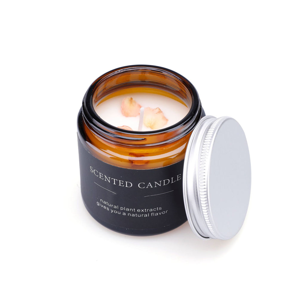 Scented candle in an amber glass jar with a black label on a white background