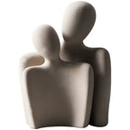 Abstract sculpture of three interconnected figures on a white background