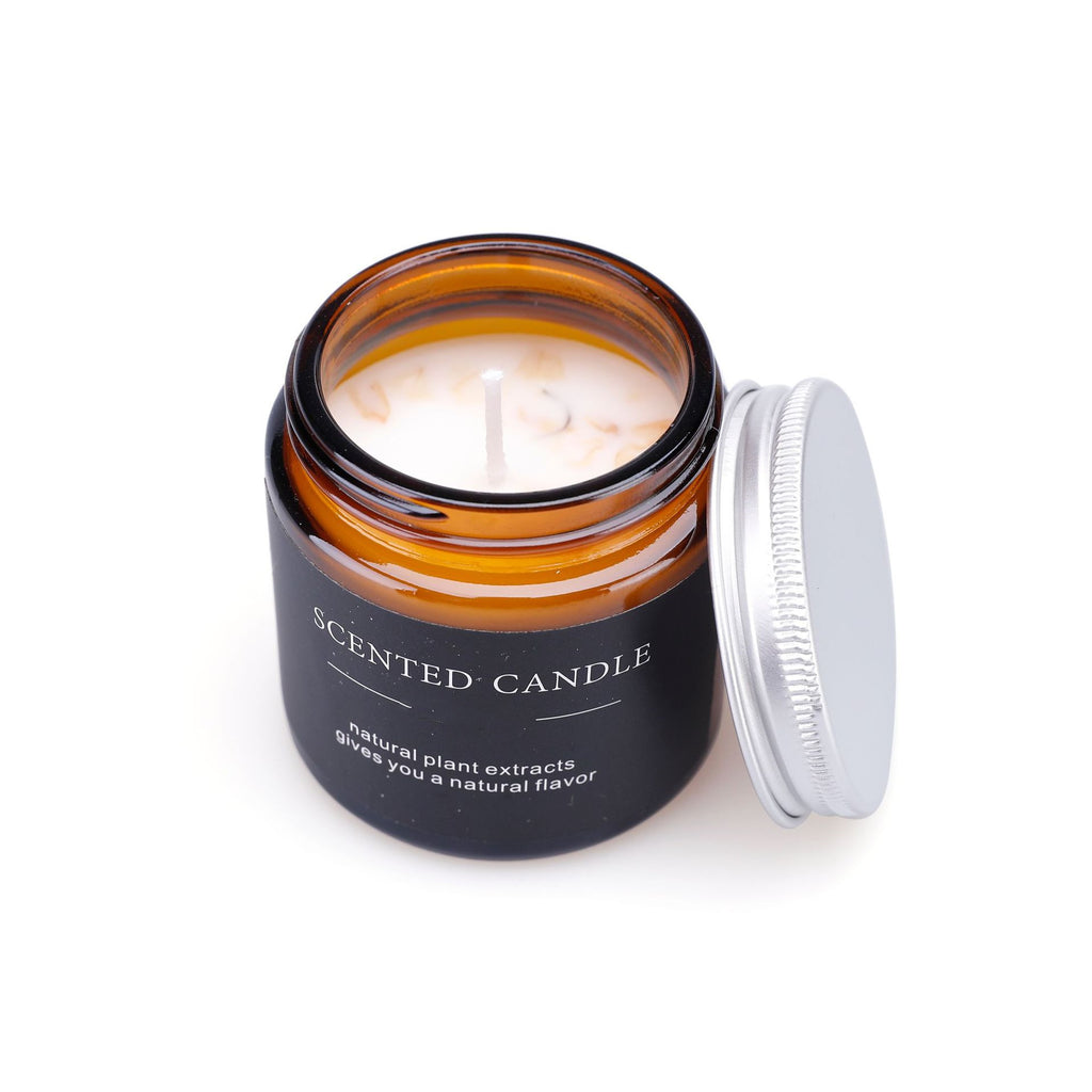 Scented candle in an amber glass jar with a black label on a white background